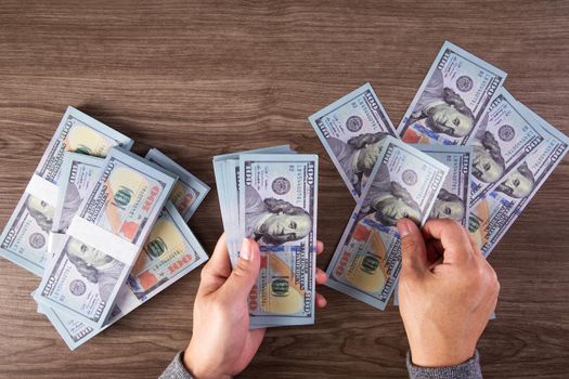 woman counting American money or 100 USD dollars note at table,finances, accounting and business concept