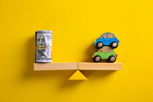 Car / Auto loan or transforming assets into cash concept : Car model, US dollar notes in jute bags on simple balance scale, depicts car owner or borrower turns personal properties into cash or wealth.