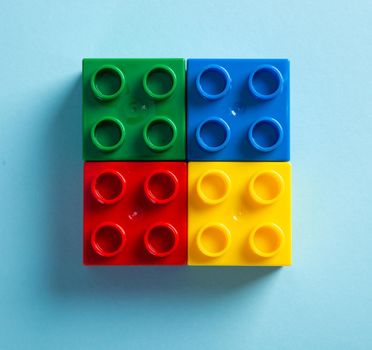 Plastic building blocks on blue background
