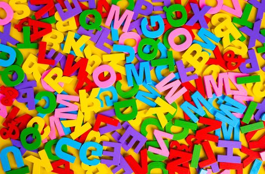 Top view colorful letters on yellow background