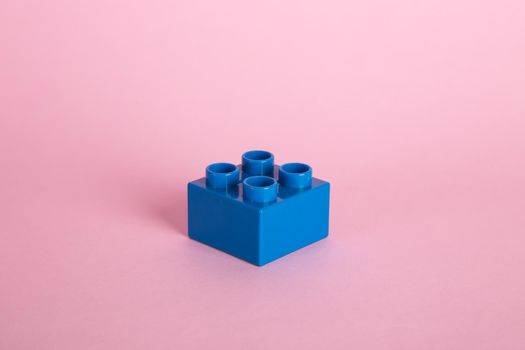 Plastic building blocks on pink background