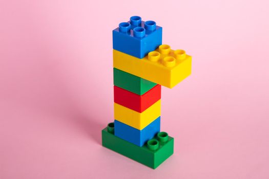 Plastic building blocks on pink background