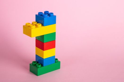 Plastic building blocks on pink background
