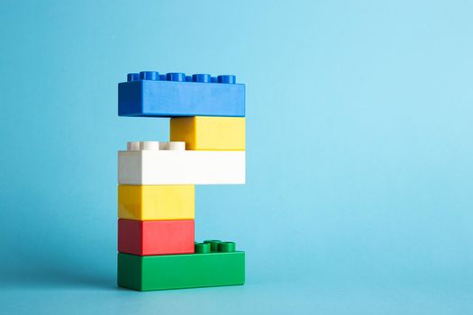 Plastic building blocks on blue background