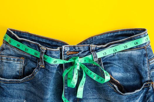 jeans with meter belt slimming on the yellow background. Diet ans slimming concept