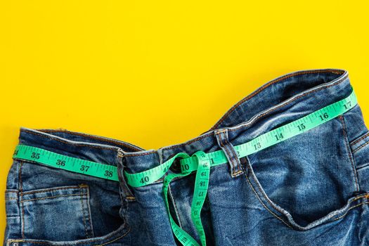 jeans with meter belt slimming on the yellow background. Diet ans slimming concept