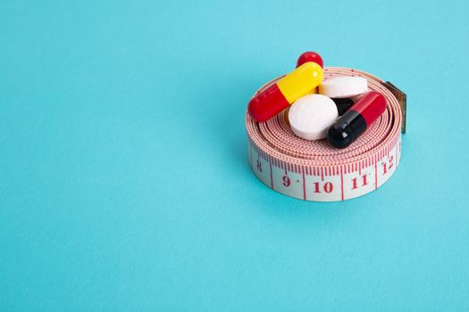 Measuring tape and pills for dieting concept. EKG medical health care and prevention.