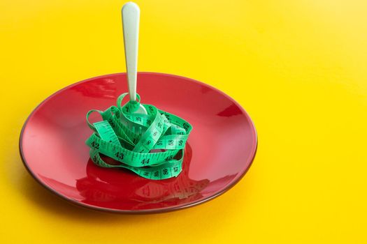 Diet for weight loss concept. Proper nutrition. Empty plate with fork and measuring tape.