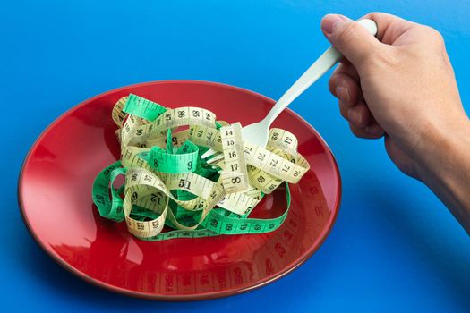 Diet for weight loss concept. Proper nutrition. Empty plate with fork and measuring tape.