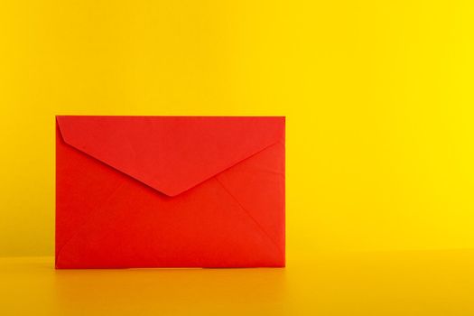 Colorful paper envelopes on yellow background - top view