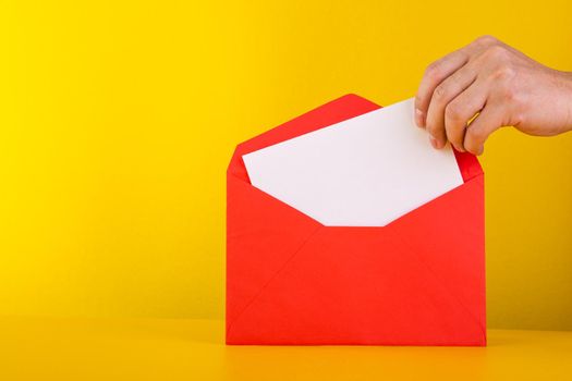 Colorful paper envelopes on yellow background - top view