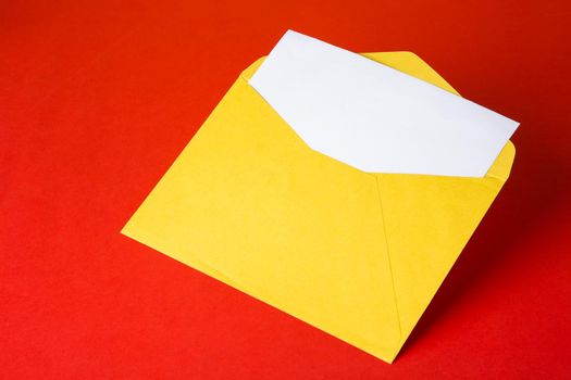 Colorful paper envelopes on red background - top view