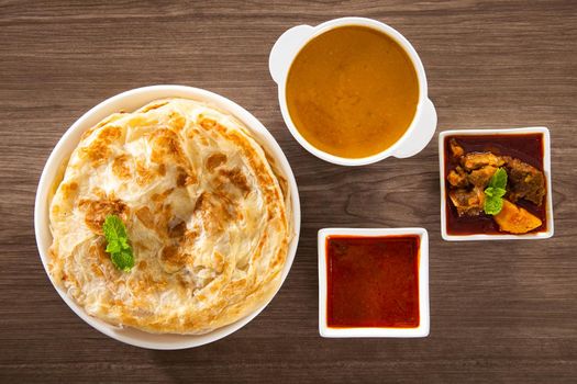 Roti Parata or Roti canai with lamb curry sauce - popular Malaysian breakfast