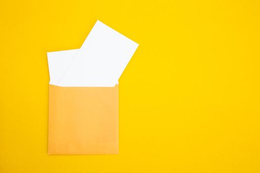 Colorful paper envelopes on yellow background - top view