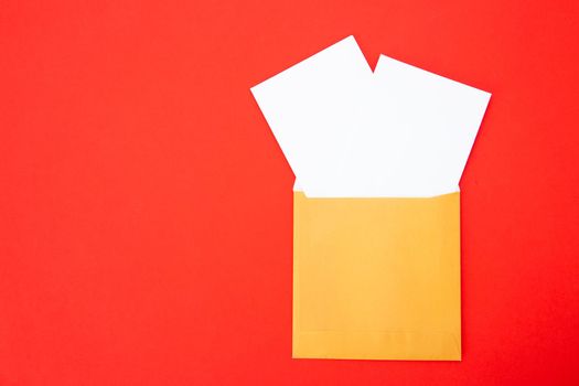 Colorful paper envelopes on red background - top view