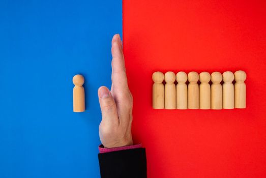 Hand of businessman stops falling figures of people (employees). Finance crisis and risk