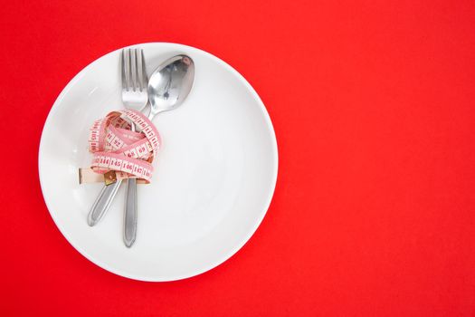 Measuring tape on a fork and knife - dieting concept