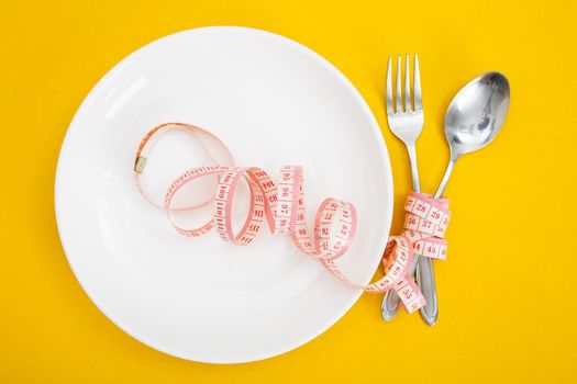 Measuring tape on a fork and knife - dieting concept