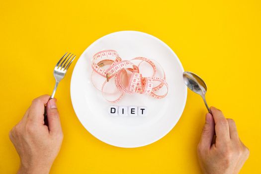 Measuring tape on a fork and knife - dieting concept