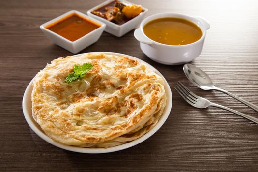 Roti Parata or Roti canai with lamb curry sauce - popular Malaysian breakfast