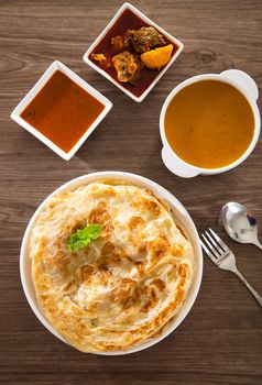 Roti Parata or Roti canai with lamb curry sauce - popular Malaysian breakfast