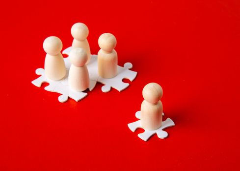 Wooden figures on puzzles on red background as a symbol of team building. Organization group people in business. Cooperation and partnership.