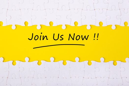Top view of jigsaw puzzle with word JOIN US. Business and education concept.