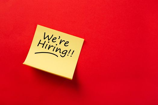 Sticky note on red background, We're hiring