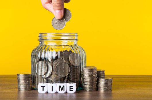 A lot coins in glass money jar with yellow background. Saving for Investment concept.