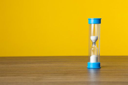 Time sand on yellow background. Time Concept