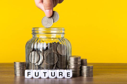 A lot coins in glass money jar with yellow background. Saving for Future concept.