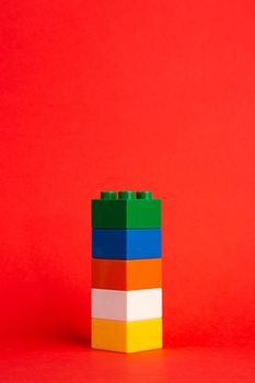 Plastic building blocks on red background