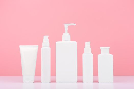 Set of cosmetic products for skin and body care on white table against bright pink background. Concept of health care and beauty