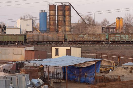 Industrial site, barrels, pipes, railway freight cars. Industrial zone of a mining enterprise.