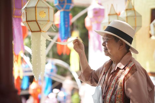 asian old elderly elder woman with hanging decorative festive paper lantern
