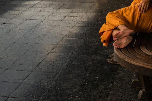 Bangkok, thailand - Jul 7, 2019 : A monk is sleep on wooden chairs are waiting for trains in the area provided at Main railway station of Hua Lamphong, Selective focus.