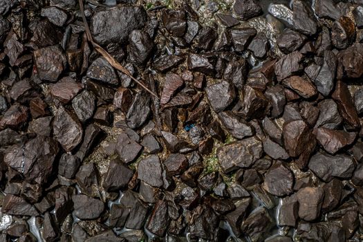 Ballast stone gravel soaked with engine oil in the railroad tracks, Stone background.