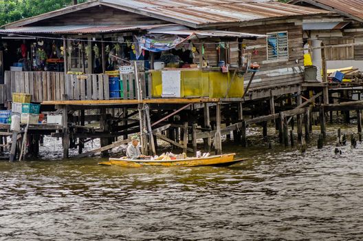 Bangkok, Thailand - Jun 30, 2019 : Uncle selling fruits on old boat on the river, Foods for villager riverside.