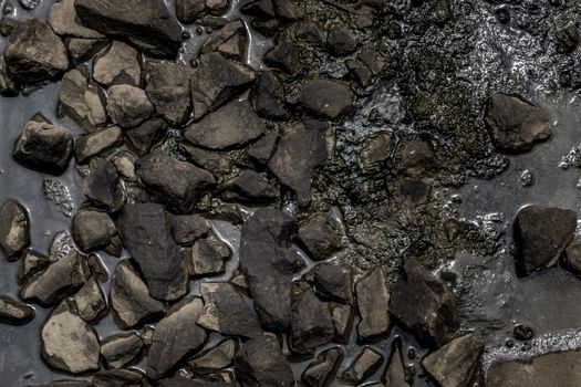Ballast stone gravel soaked with engine oil in the railroad tracks, Stone background.