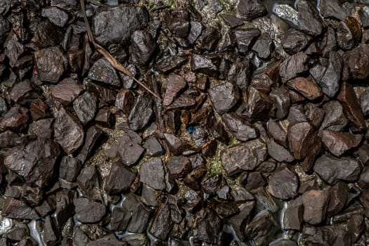 Ballast stone gravel soaked with engine oil in the railroad tracks, Stone background.