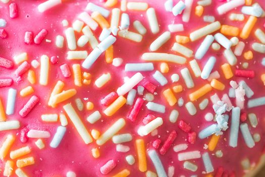 Close up of sugar sprinkled pink donut glace