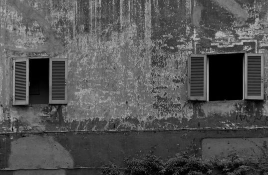 Two open windows in a weathered wall