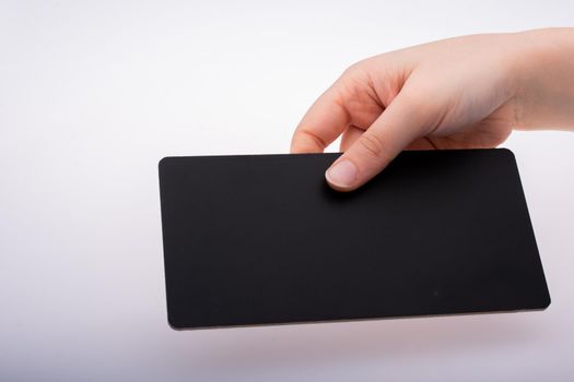 Rectangular shaped black notice board in hand on white background