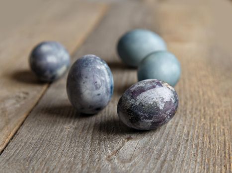 Painted chicken eggs on surface of wooden planks. Selective focus