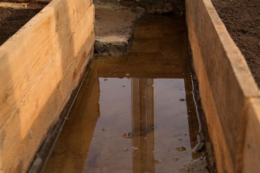 Melt water flooded path between beds in greenhouse.