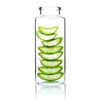 Homemade skin care with aloe vera slice in a glass bottle isolated on white background.