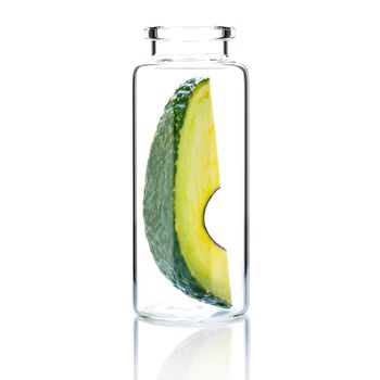 Homemade skin care with  avocado slice in a glass bottle isolated on white background.

