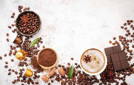 Background of various coffee , dark roasted coffee beans , ground and capsules with scoops setup on white concrete background with copy space.