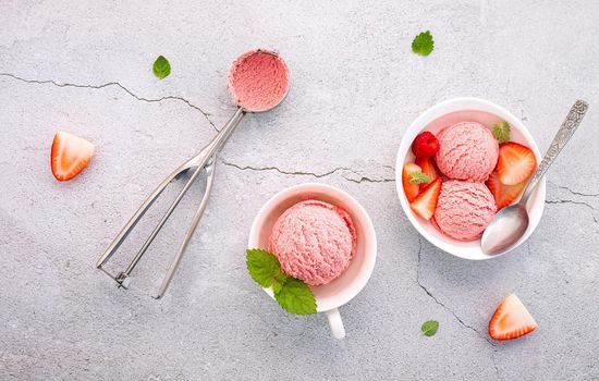 Strawberry  ice cream flavour in white  bowl setup on concrete background . Summer and Sweet menu concept.