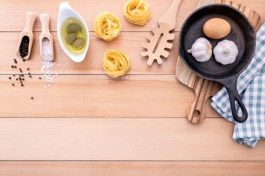 Italian foods concept and menu design . Empty cast iron skillet and  pasta ladle on wooden background.